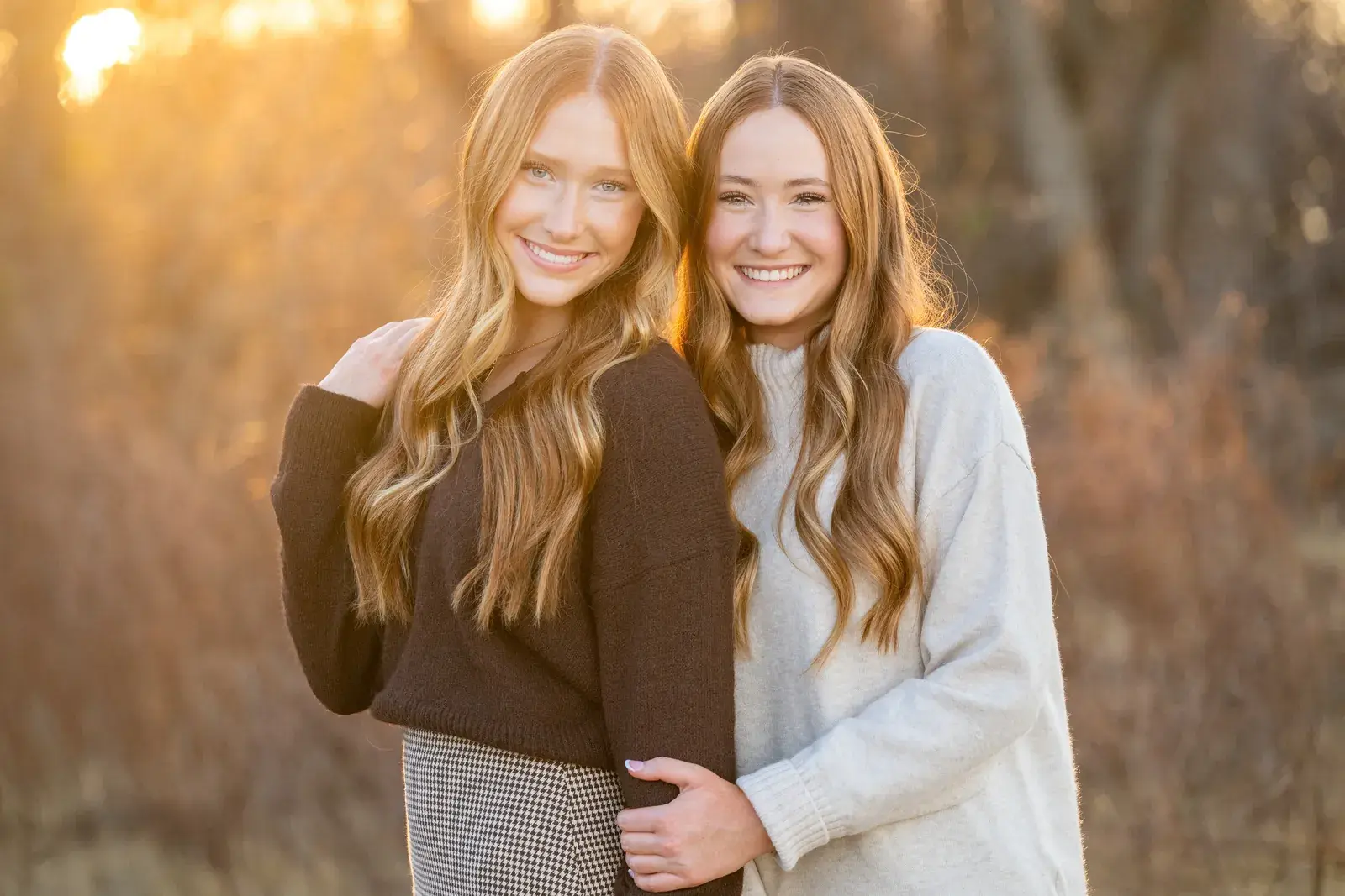 Two sisters at golden hour in a winter field