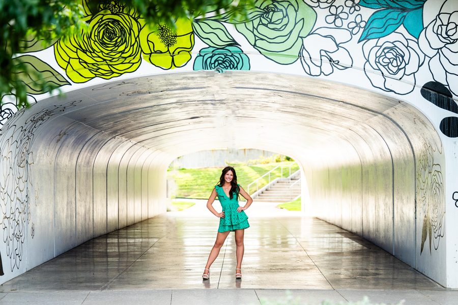 Senior in a green dress in a mural tunnel