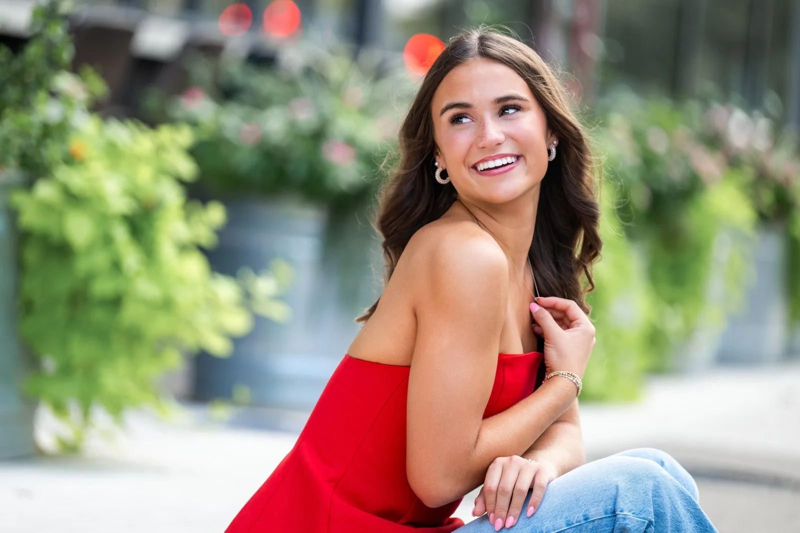 Senior girl in a red top laughing on a downtown street