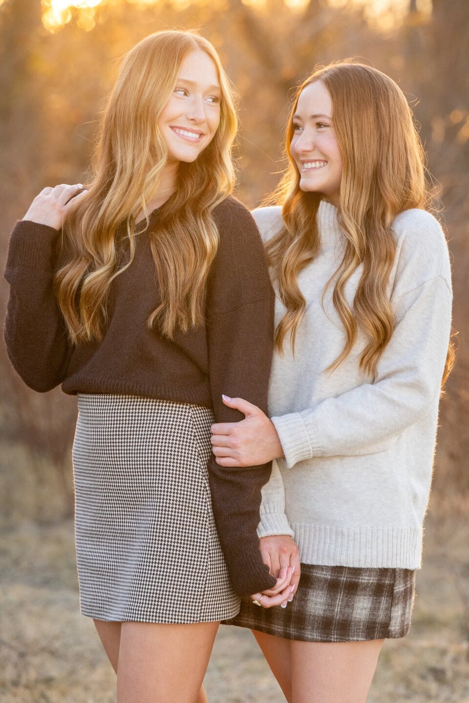 Two sisters at golden hour in a winter field